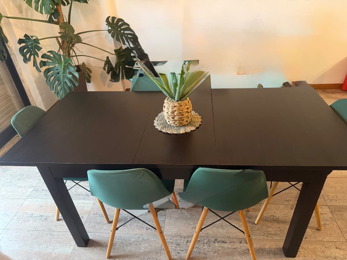 Mesa de jantar extensível preta com 6 cadeiras estilo Eames verdes